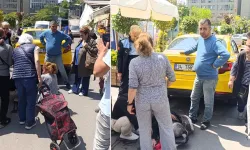 Geri geri giden taksi, yaşlı kadını altına aldı