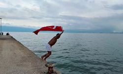 Bursa'da soğuk ve yağışlı havaya aldırmadı, Türk bayrağıyla denize girdi!