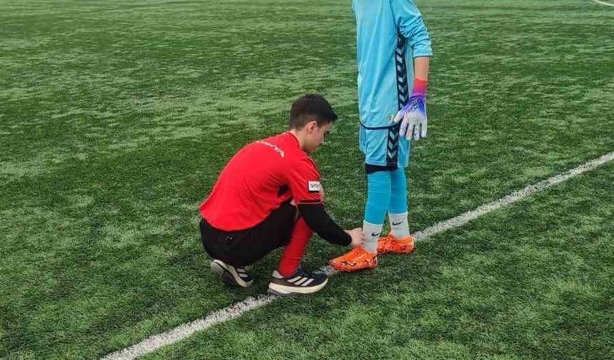 Hakem futbolcunun kramponlarını bağladı