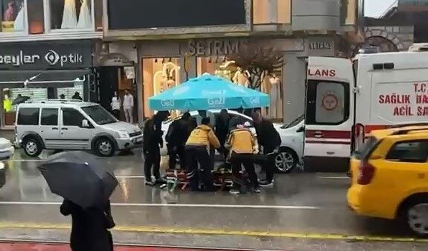 Bursa'da yolun karşısına geçerken otomobil çarptı: Vatandaşlar yaralıya şemsiye tuttu!