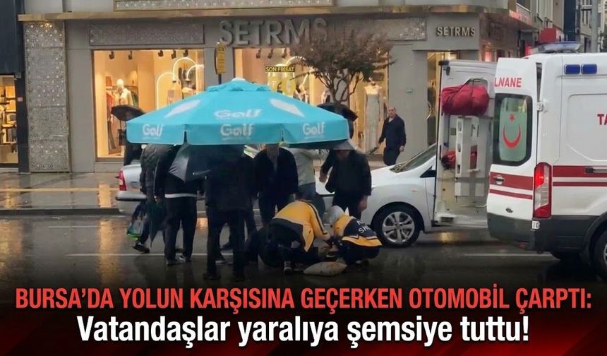 Bursa'da yolun karşısına geçerken otomobil çarptı: Vatandaşlar yaralıya şemsiye tuttu!