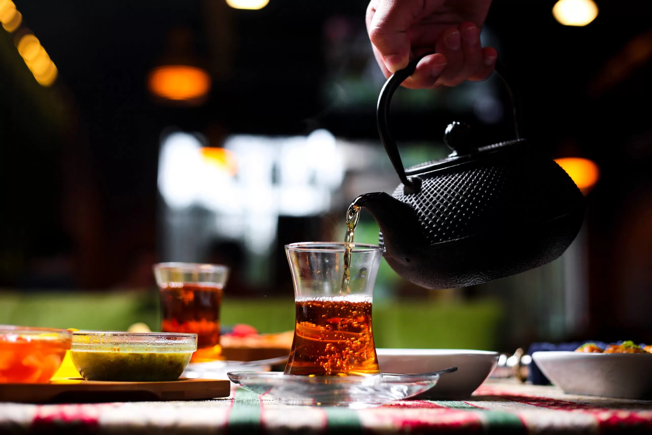 Man Pouring Tea Into Armudu Glass From Stone Teapot 2 Scaled