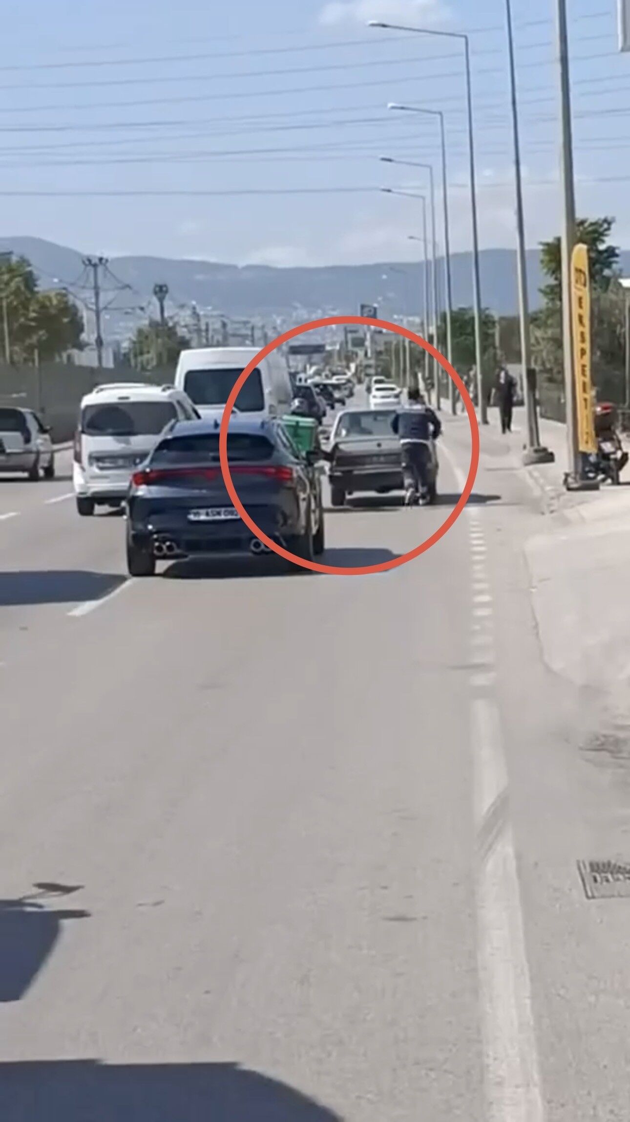 Bursa'da motokuryeden arızalanan otomobili itmek için ilginç yöntem